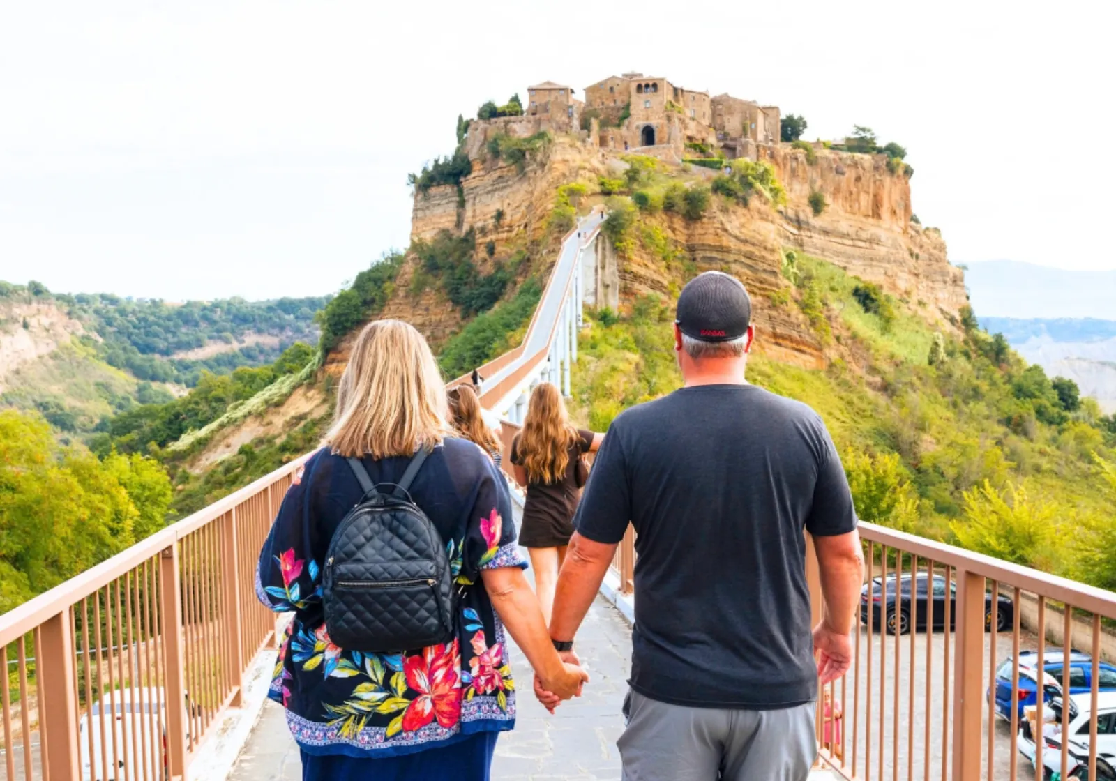 Visitors walking along the footbridge toward Civita di Bagnoregio on its cliff-top rock
