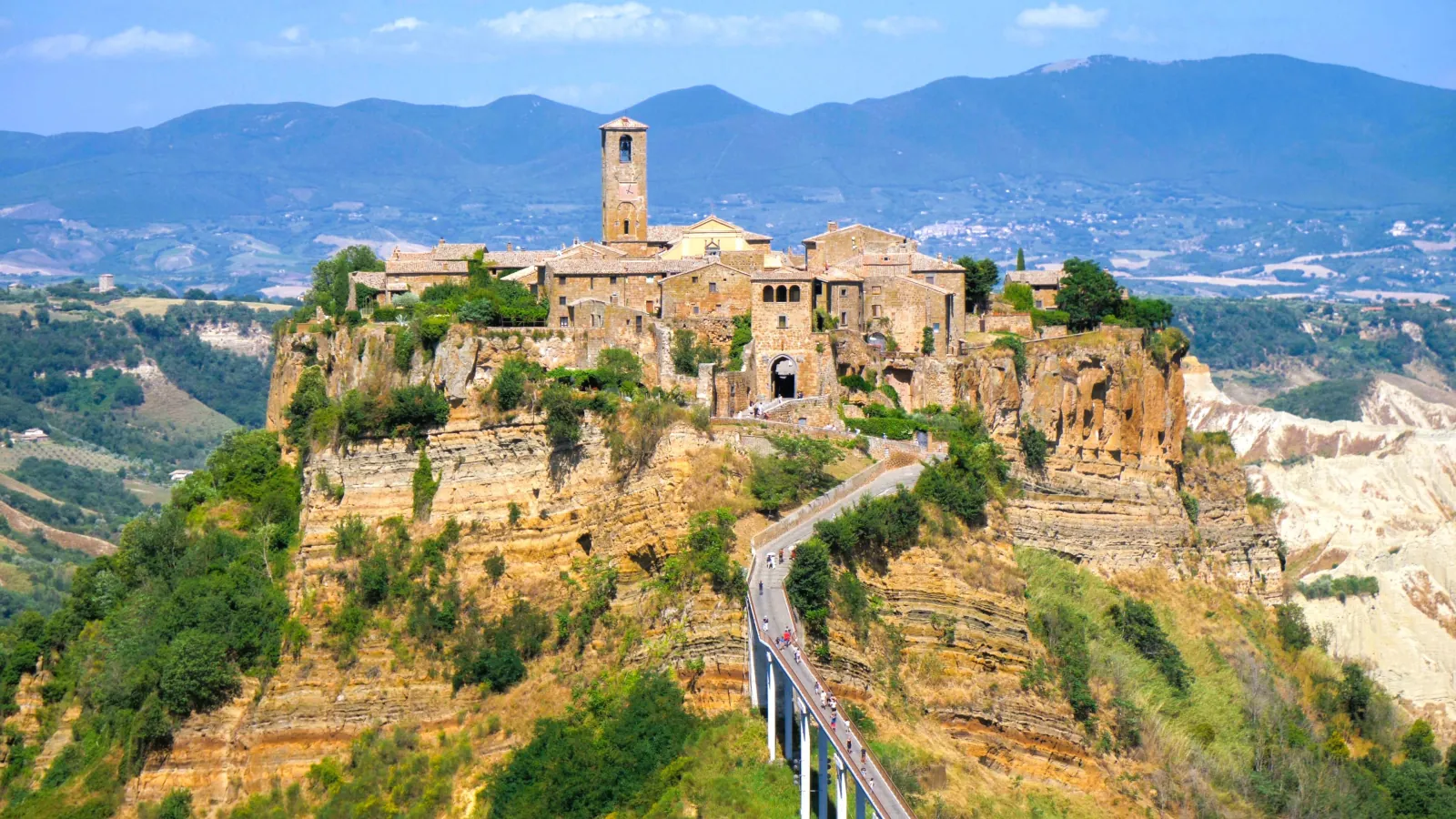 Civita di Bagnoregio village on its eroded clifftop with the long footbridge and mountains behind