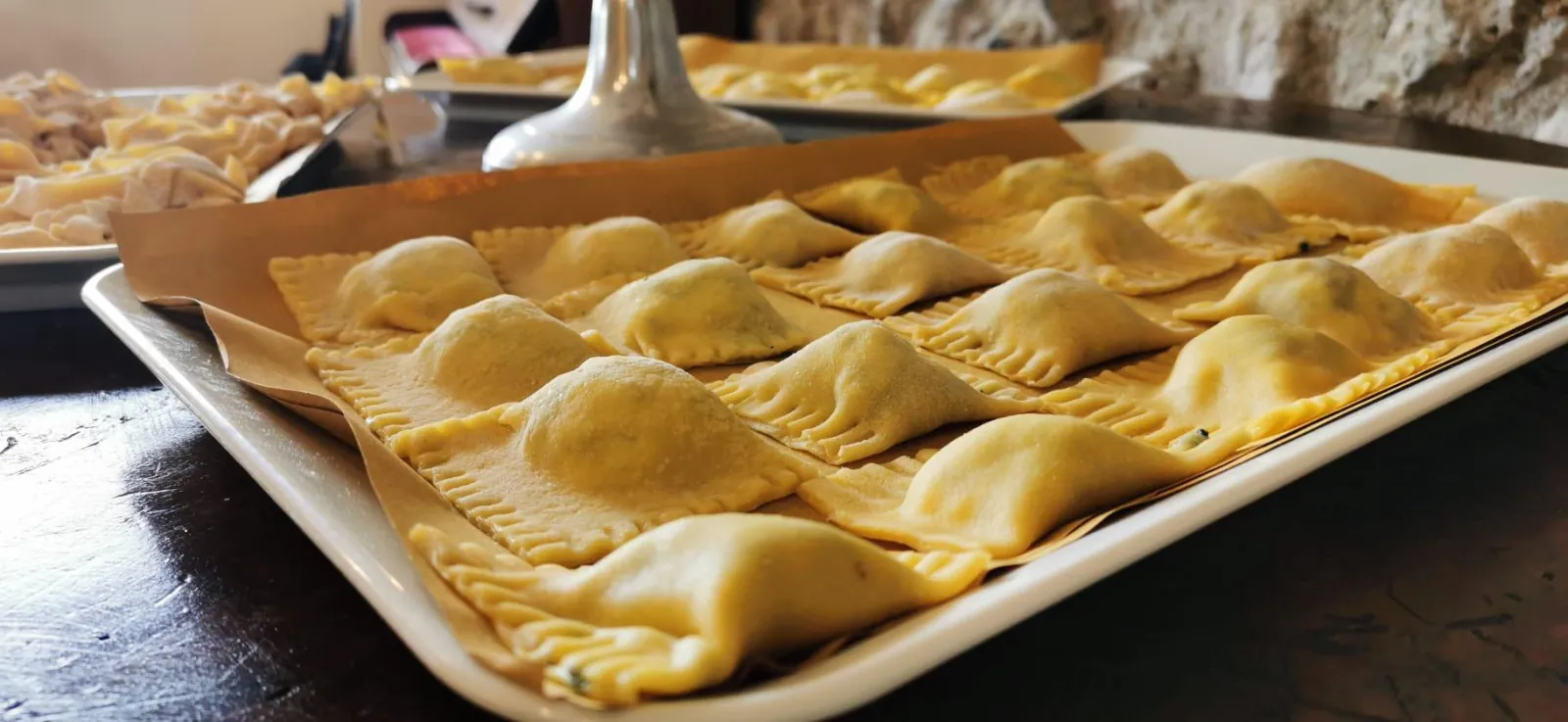 Tray of freshly made filled ravioli on baking paper
