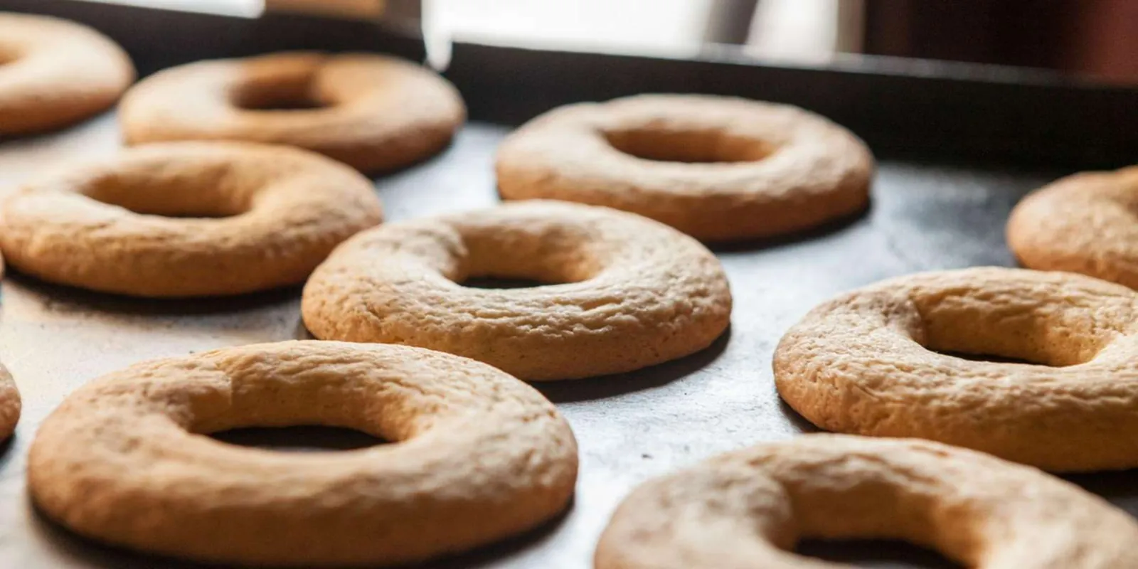 Tray of ring-shaped baked biscuits on a baking sheet, close up